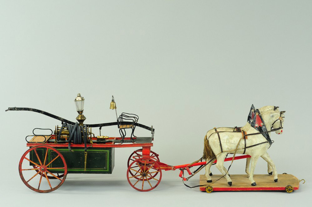EARLY BING FIRE PUMPER: Germany, c. 1900, hand painted open hand pump fire wagon has center lantern, spoke wheels, high open bench seating, includes two horses on wheeled platform. 19" l.