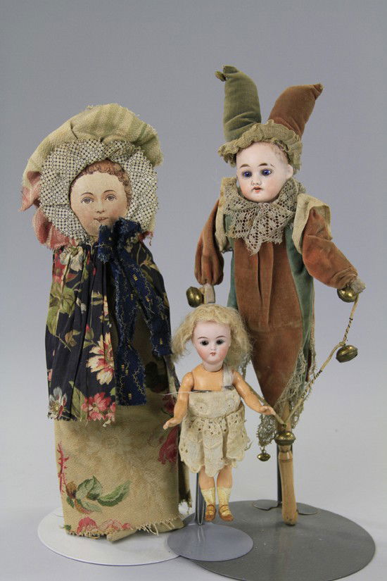 LOT OF THREE DOLLS: Consists of a bisque head jester with bellows in torso and a wooden handle with whistle capability, bisque head doll incised "890" on five piece composition body with molded shoes and stockings (facto