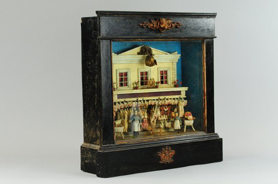 MID 19TH CENTURY CARVED BUTCHER SHOP: One of the most detailed displays of its kind; the two-story structure features windows with curtains on second floor and showcased by complete carvings of varied meats hanging at floor level. An amaz