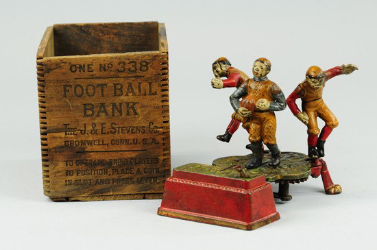 CALAMITY MECHANICAL BANK WITH ORIGINAL BOX: J & E Stevens Co., designed by James H. Bowen, patented 7/30/1904. Move the right and left tackles back to position, place a coin in the slot in front of the Full Back and press lever. As the players 
