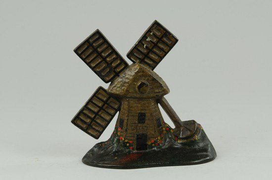 WINDMILL DOORSTOP: "Pat. De. 15, 1925," cast windmill done in tan, colorful flowers surrounding base of windmill. 6 7/8" x 7 1/2" w.