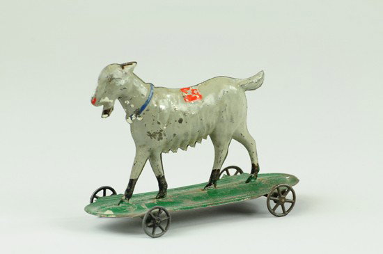 GOAT PULL TOY: Hull & Strafford, c. 1880's, early American tin toy, hand painted in grey body, black hoofs, green wheeled platform. 6 1/4" l.
