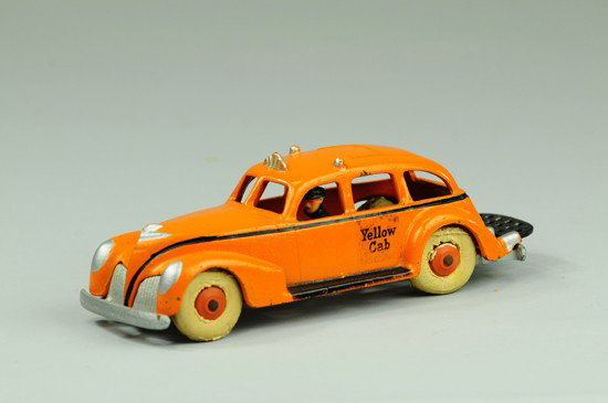 YELLOW CAB: Hubley, cast iron, painted in orange overall, cast driver, white rubber tires, silver chassis and black luggage rack. 8" l.