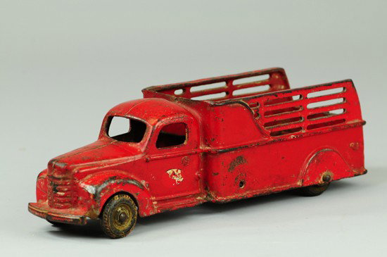 1941 INTERNATIONAL STAKE TRUCK: Arcade, cast iron, painted in red overall, painted IH decals on doors, open stake body, enclosed cab, black rubber tires. 11 1/2" l.