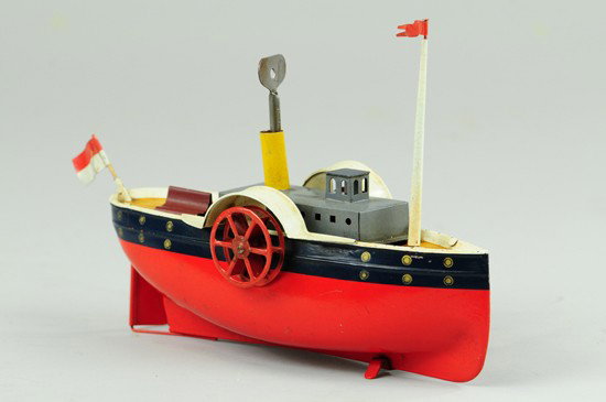 BING PADDLE WHEELER: Germany, hand painted in red and blue hull, red side wheels, single stack conceals clockwork key mechanism, grey cabin, rear bench seating. 8 1/2" l.