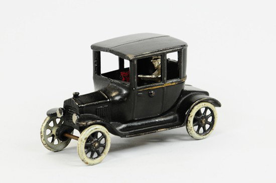 MODEL 'T' COUPE: Arcade, cast iron, painted in black overall, gold side stripe, white wheels, black spokes, seated removable nickel driver. 6 1/2" l.