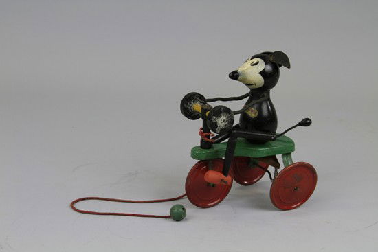 IGNATZ MOUSE ON TRICYCLE: 1932 King Features Syndicate, Chein, made of wood body and seated on green tin tricycle with red tin disc wheels, features label on chest, legs are articulated, bellows appear under base and emits squ