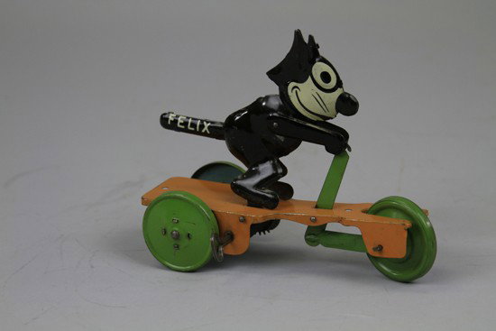 FELIX ON SCOOTER: Nifty, lithographed tin, Felix stands on bright yellow scooter with green disc wheels, marked "Felix" on tail, wind up action. 7 1/2" l.