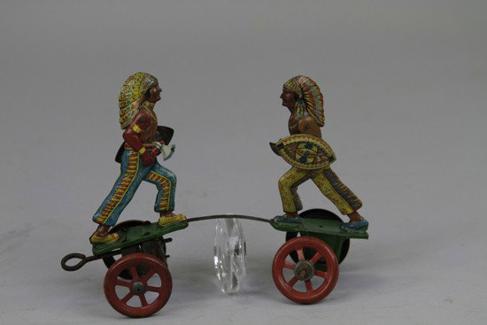 BATTLING INDIAN WARRIORS: Germany, scarce example, lithographed tin, amusing toy depicts two Indian figures on steel band connected platforms in war dress seemingly battling when key wind is operated. 6 3/4" l.