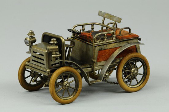 EARLY RUNABOUT CIGARETTE HOLDER: Germany, these are very scarce today, rear seat and front grille lift to reveal area for cigarettes and match storage, nickel finish, wood trim, rubber tires. 6 3/4" l.