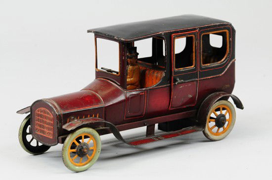LIMOUSINE: Bing, Germany, c. 1920, lithographed tin, bright graphic colors of red with yellow striping, seated chauffeur, opening doors, nickel side lamps, spoke wheels, clockwork driven. 12 3/4" l.