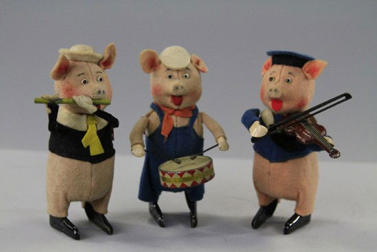 THREE LITTLE PIGS: Schuco, Germany, clockwork operated, each depicted with instrument in hand, full felt outfits. 5" h.
