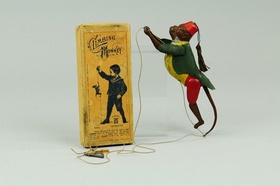 BOXED CLIMBING MONKEY: Lehmann, Germany, lithographed and hand painted tin, rough sprayed green jacket, amusing action, as child holds down string with foot and pulls other end, monkey able to rise and climb, concealed mech