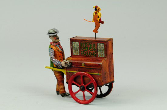 DISTLER ORGAN GRINDER: Germany, lithographed tin, classic depiction of street performing walking organ grinder with dancing monkey, large spoke wheels, clockwork driven. 6" h.