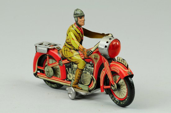 MAN RIDING MOTORCYCLE: Arnold, Germany, lithographed tin, done in red cycle, brown outfit, light at front, luggage rack on fender, key wind driven. 7 1/4" l.