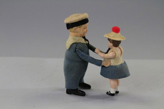 SCHUCO DANICNG SAILOR GIRL: Germany, pre-war example, couple dressed in blue outfits, tin boy, girl has celluloid head and arms. 5" h.