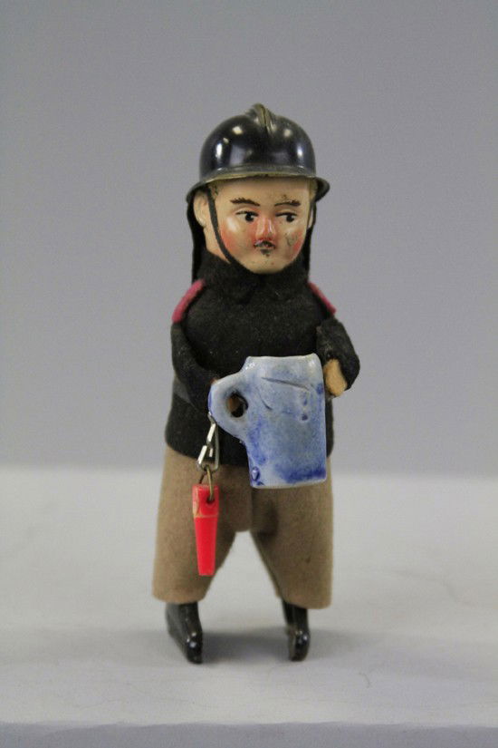 SCHUCO FIREMAN WITH STEIN: Germany, scarce example, depicted with plastic helmet, holds ceramic beer stein in hand, clockwork. 5" h.