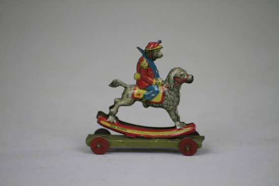 MONKEY ON ROCKING DOG PENNY TOY: Embossed lithographed tin, a charming fantasy penny toy by Meier with colorful action. 3" l.