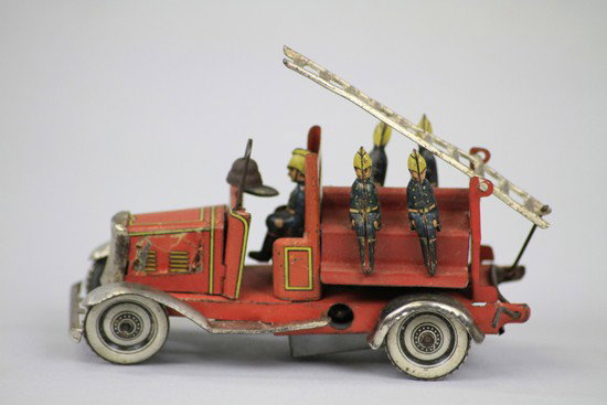 FIRE LADDER TRUCK PENNY TOY: Germany, elaborate tin lithographed ladder truck containing five seated firemen and overhead ladder, nickeled bumpers and fenders, clockwork mechanism. 4 1/4" l.