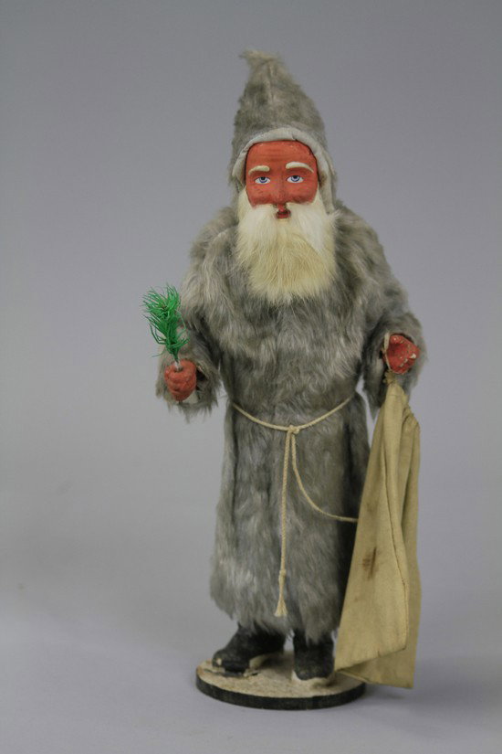 UNUSUAL BELSNICKLE IN SILVER FOX FUR ROBE: This candy container is molded with terrific form including his long fur robe and hood, strong coloring throughout, gentle face with rabbit fur beard, posed in welcoming appearance. 15" h.