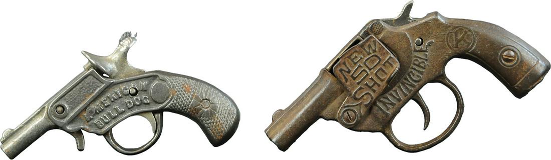 TWO CAST IRON CAP GUNS: 350. TWO CAST IRON CAP GUNS | Lot includes; Invincible and American bulldog blank shooter cap guns. | 5.5" l. | (Very Good Condition) | $75 - $150