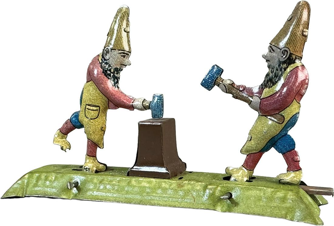 MEIER GNOMES AT ANVIL ARTICULATED PENNY TOY: 193. MEIER GNOMES AT ANVIL ARTICULATED PENNY TOY | Germany. Hand plunger causes figures to move forth and back | 4.25" l. | (Pristine to Near Mint Condition) | $150 - $300