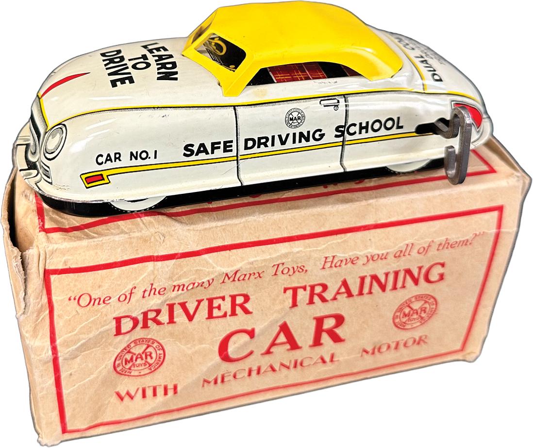 BOXED MARX DRIVER TRAINING CAR: 404. BOXED MARX DRIVER TRAINING CAR | USA. Wind-up causes toy to roll forward | 6.5" l. | Box is complete though it has some handling tears at end seams and slight crushing on one end, toy in (Pristin