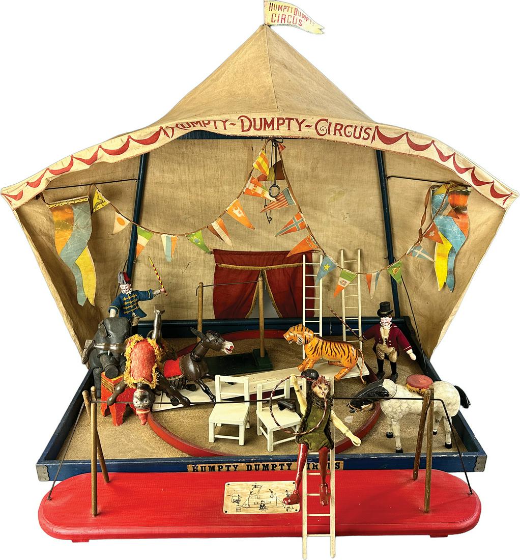 SCHOENHUT HUMPTY DUMPTY CIRCUS TENT DISPLAY: 468. SCHOENHUT HUMPTY DUMPTY CIRCUS TENT DISPLAY | USA | 36" l. | Red base of trapeze bar is overpainted, largest banner is replaced, two white chairs are overpainted, overall in (Excellent Condition)