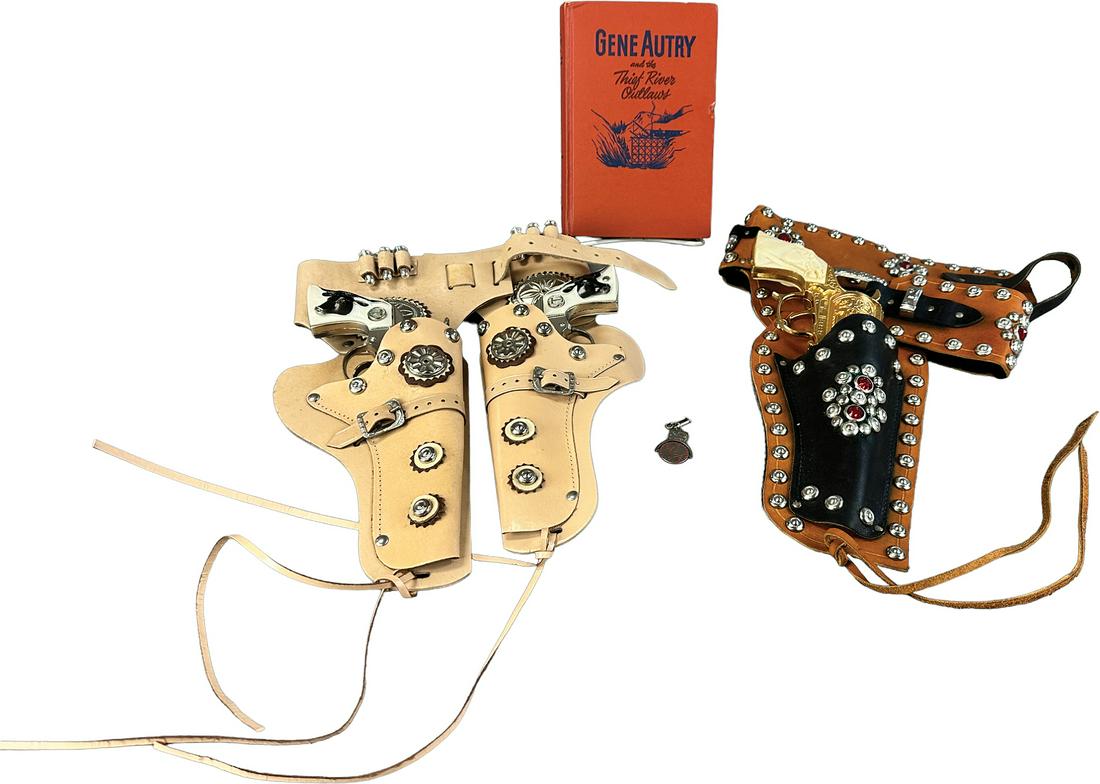 TEXAS WILD BILL & GENE AUTRY LOT: 484. TEXAS WILD BILL & GENE AUTRY LOT | Lot includes Texas Wild Bill holster sets, a Gene Autry book, and a pin. | Holster 13.5" l. | Book and holsters in (Excellent Condition) | $200 - $400