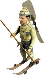 GERMAN SKIER W/ PROPELLER BLADE: 226. GERMAN SKIER W/ PROPELLER BLADE | Attributed to Hans Eberl, rare German tin toy, a curious design depicting a skier with a propeller attached to his back to cause forward rolling motion. | 8.25"