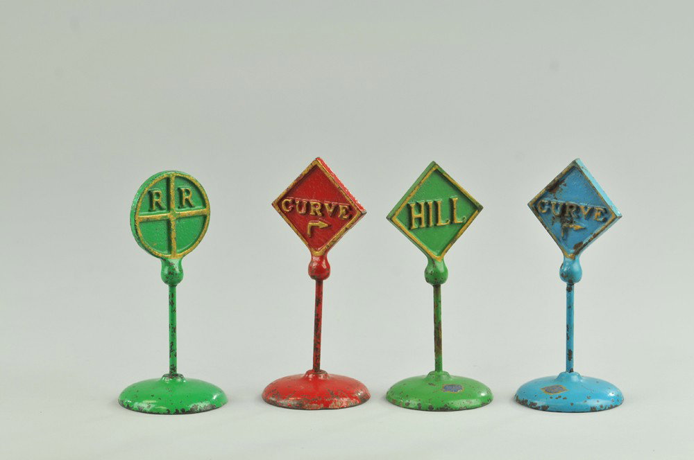 LOT OF FOUR ROAD SIGNS: Arcade, cast iron, various colors, each marked on underside of base, three of the four have Arcade decals. 4 1/2" l. (Exc. Cond.) 4 1/2" l.