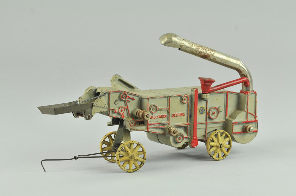 ARCADE MCCORMICK-DEERING THRESHER: Cast iron, painted in grey, extensive red trim to embossed panels, nickel feeder, cream spoke wheels, fold down chute, a nice example. 12" l. (Exc. Cond.) 12" l.