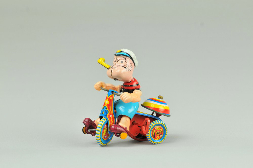 POPEYE ON TRICYCLE: Linemar, Japan, tin depiction of Popeye on tricycle, bright graphic colors w/bell on back of bike, key wind driven. 4" l. (Exc. Cond.) 4" l.