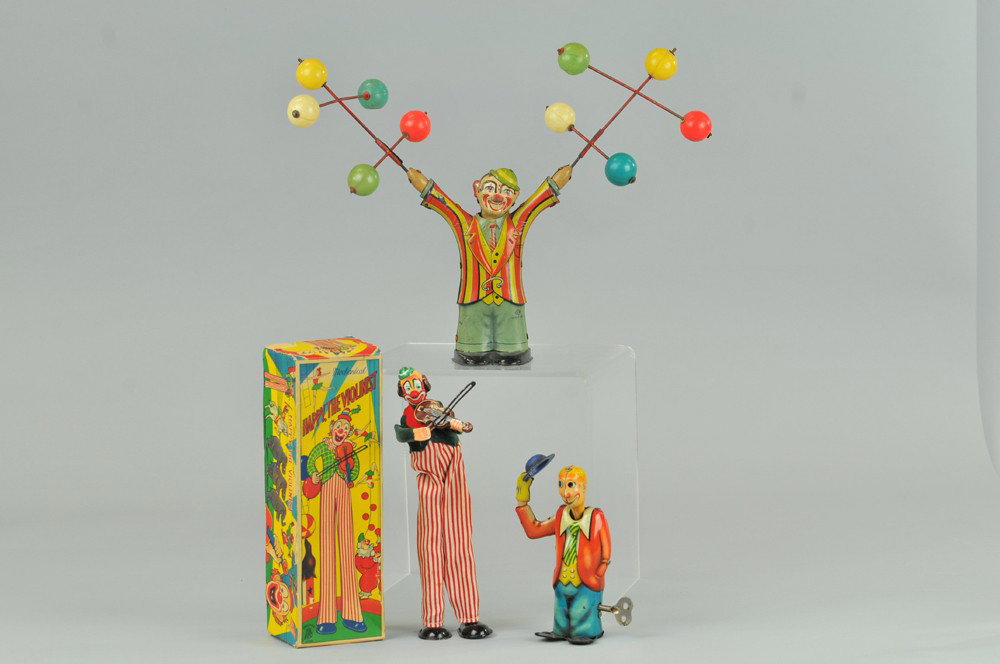 LOT OF TIN CLOWN TOYS: Three examples from Western Germany and Japan, includes clown with twirling celluloid ball props; Happy the Violinist with box, and clown with extending neck & tipping hat when wound. 6" - 10 1/2" h. 