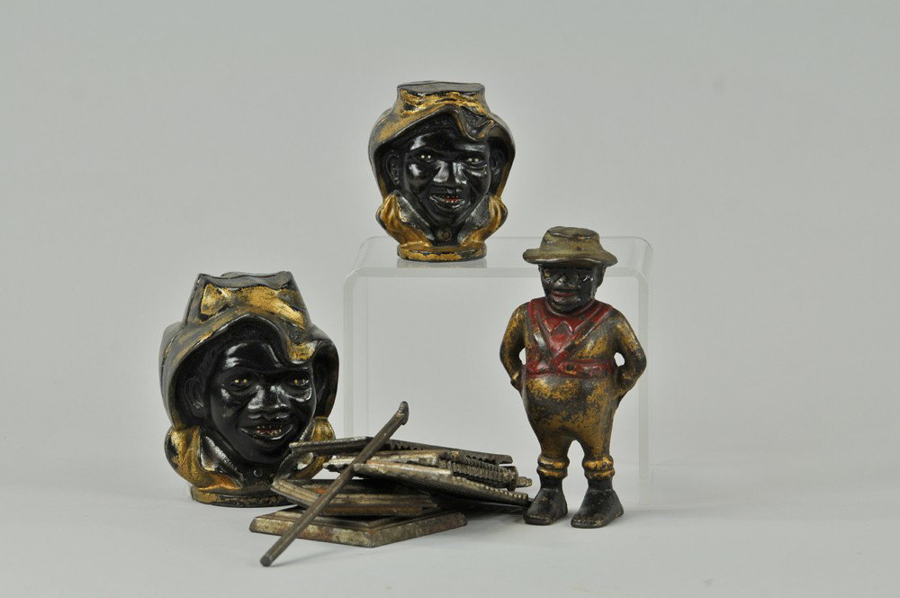 LOT OF STILL BANKS: Cast iron grouping includes: sharecropper, two sizes of two faced boys and skyscraper in silver. 3 1/4" - 5 1/4" h. Break to scraper pin, not assembled, repaint to several backs, (Fair Cond) Inv# 0057