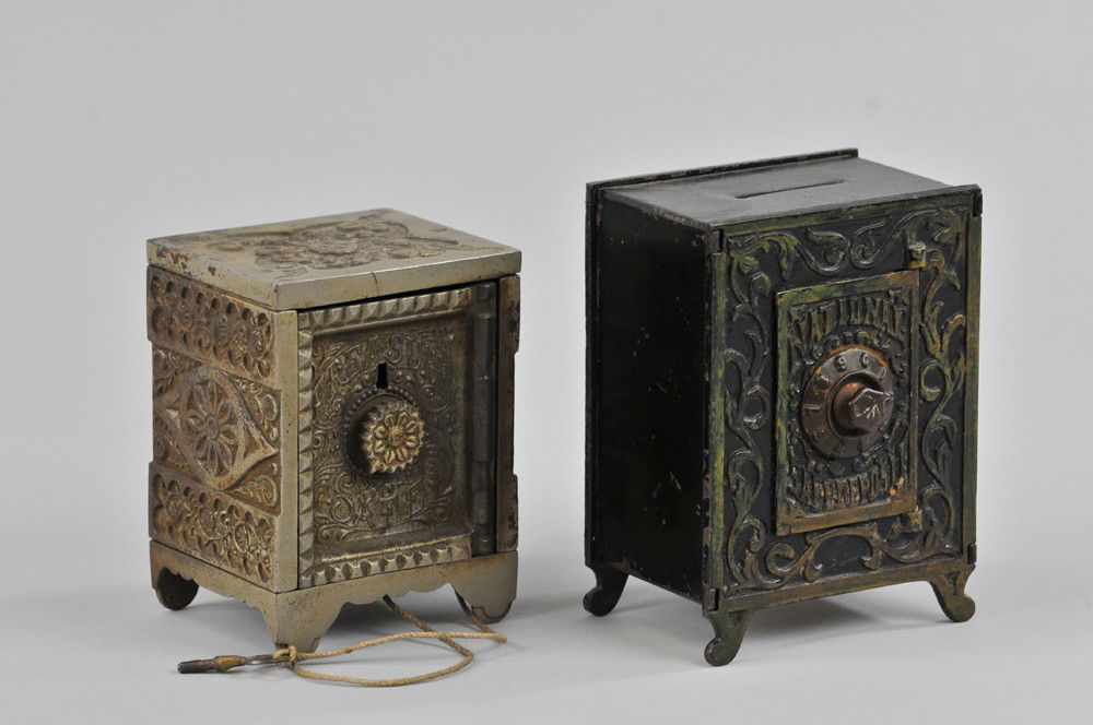 NATIONAL DEPOSIT AND TREASURY SAFE BANKS: Both cast iron, National painted in black, extensive mold effects, combo dial on door, Treasury has key lock front. 5 1/8" - 6" h. (VG Cond.) Inv# 39 5 1/8" - 6" h.
