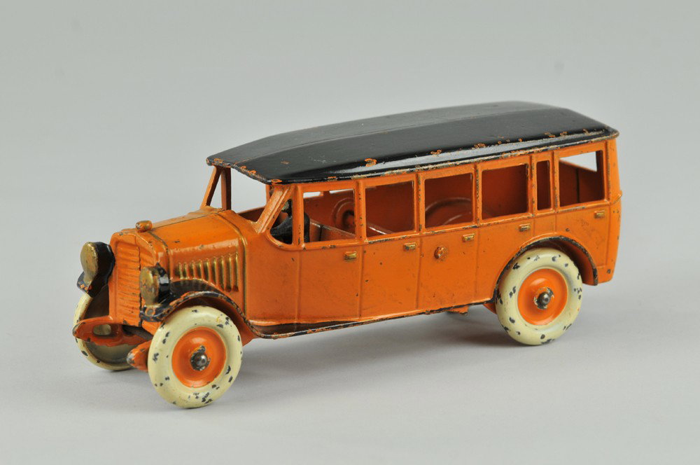 DENT INTERURBAN BUS: Cast iron, painted in orange body with black roof and fenders, cast front headlights, disc wheels are painted white and orange, individual door latches embossed on both sides. 8 1/2" l. (Exc. Cond.) 8