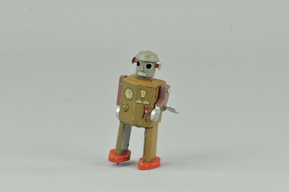 ATOMIC ROBOT MAN: Japan, lithographed tin, done in violet shade, known as one of the earliest of robot models, clockwork activated. 5 1/4" h. (VG Cond.) 5 1/4" h.