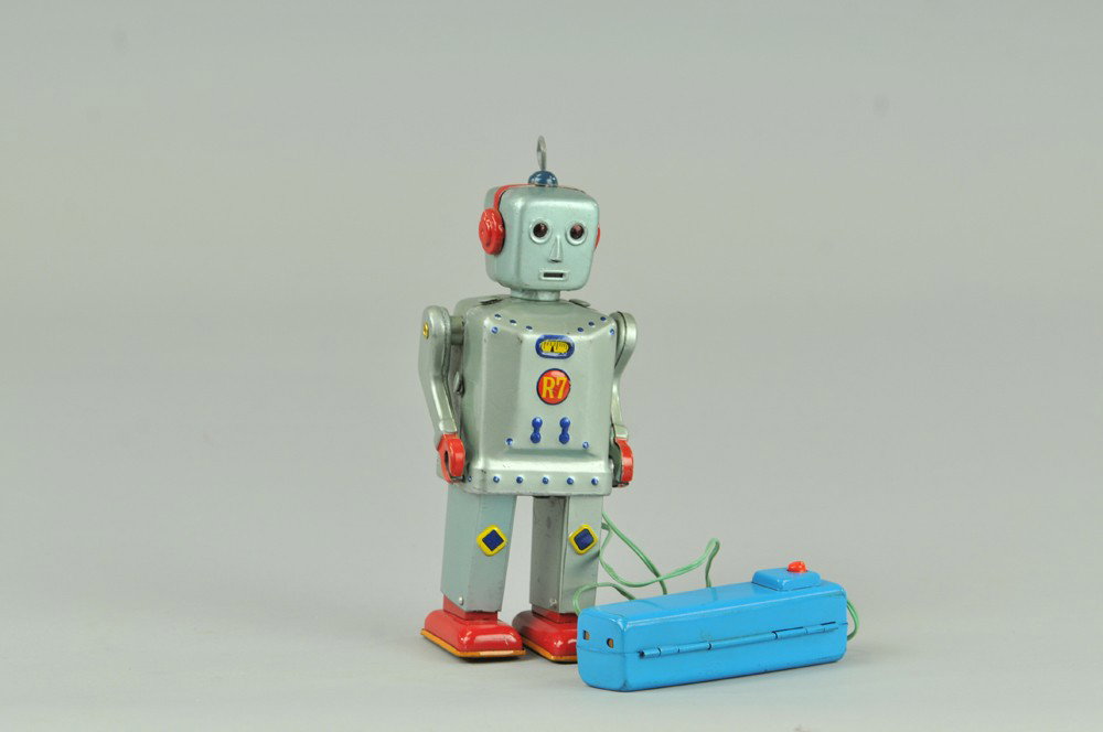 FLASHY JIM R7 ROBOT: Japanese, battery operated, remote controlled, Marked "R7" on chest operation features legs moving forward and eyes illuminating. 7 1/2" h. Some minor scratching and wear. Eyes light, not walking, (VG