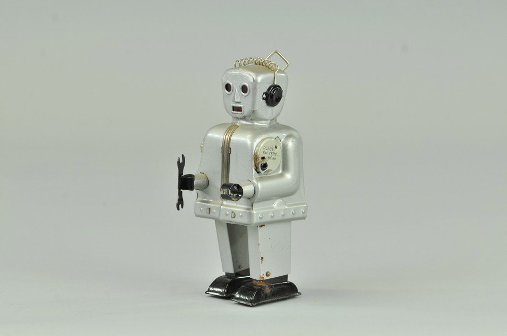 ZOOMER THE ROBOT: Nomura, Japan, c.1954, classic toy robot done in silver with nickel trim, red celluloid eyes, antenna on back pack, battery operated. 7 3/4" h. Minor corrosion at battery box, not working (VG Cond.) 7