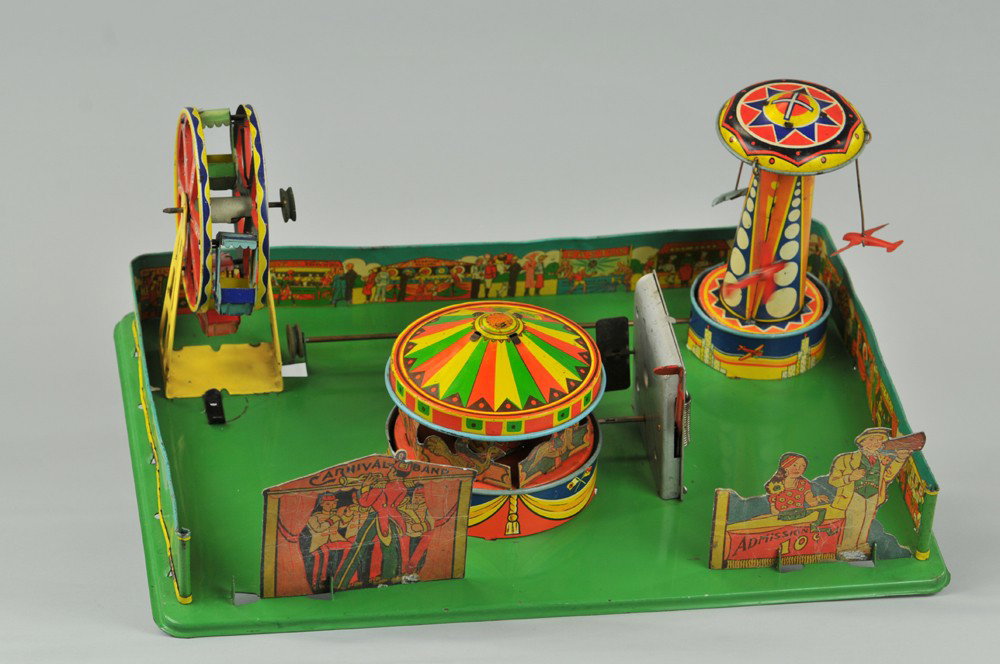 CARNIVAL TOY: Wyandotte, amusing large scale table toy, clockwork operated, pressed steel base contains circus rides done in tin lithography with cardboard die-cuts standing at base, great actions. 16" x 11 1/2" x 