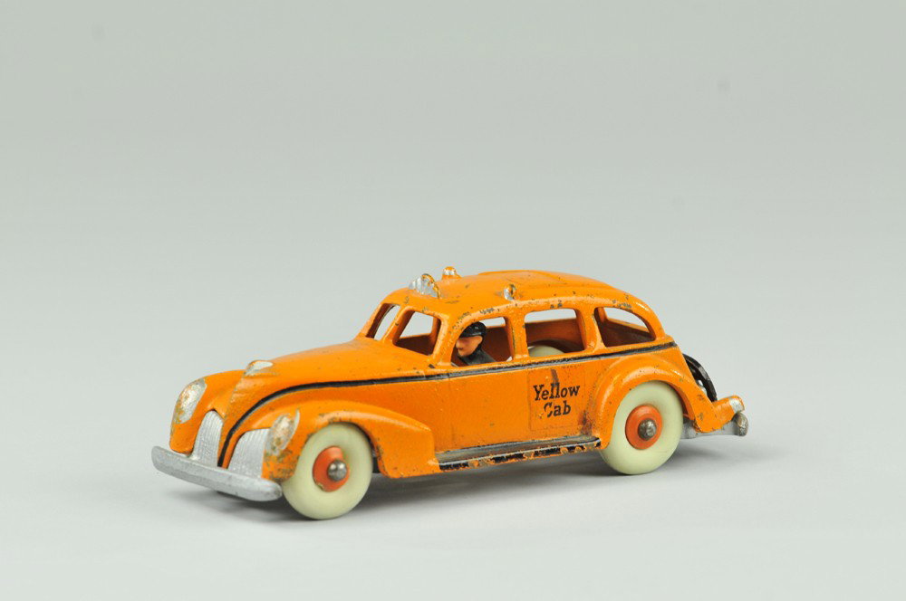 HUBLEY YELLOW CAB: Hubley, cast iron, painted in orange with silver and black highlights, rubber tires, cast driver in blue uniform, reads "Yellow Cab" on sides. 8" l. (VG Cond.) 8" l.