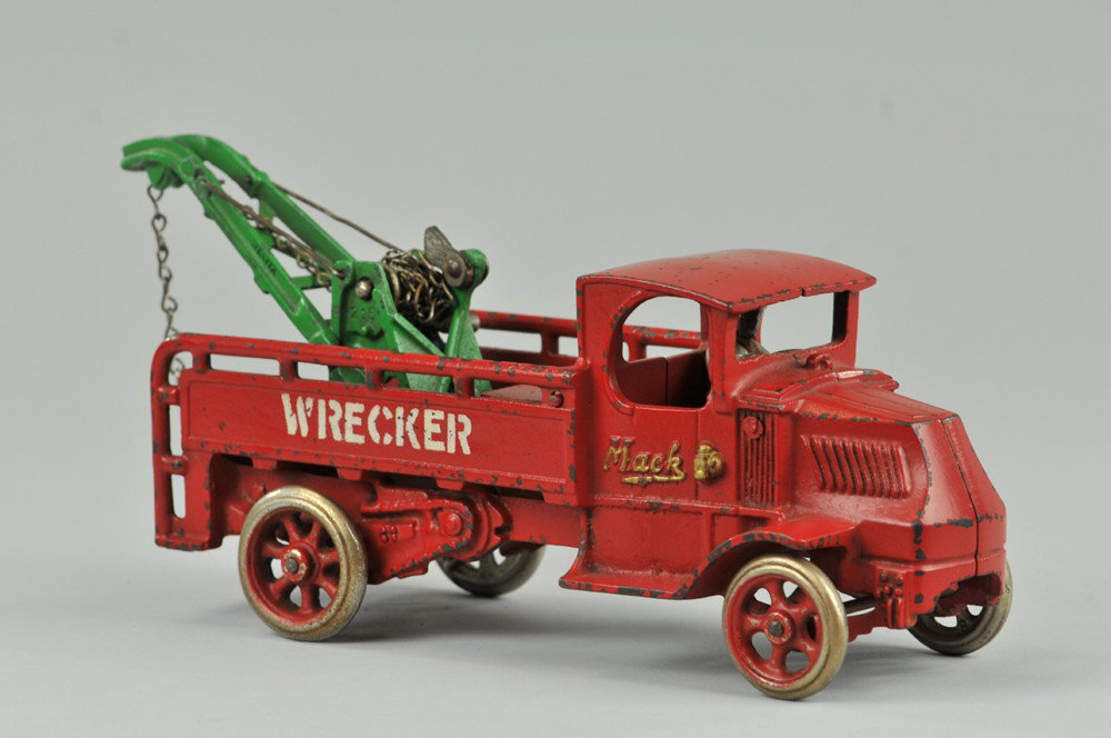 MACK WRECKER: Arcade, cast iron body stenciled "Wrecker" on sides, painted in red with green Weaver crane on railed open body, nickel spoke wheels, red painted centers, nickel plated driver. 12" l. (Exc. Cond.) 12"