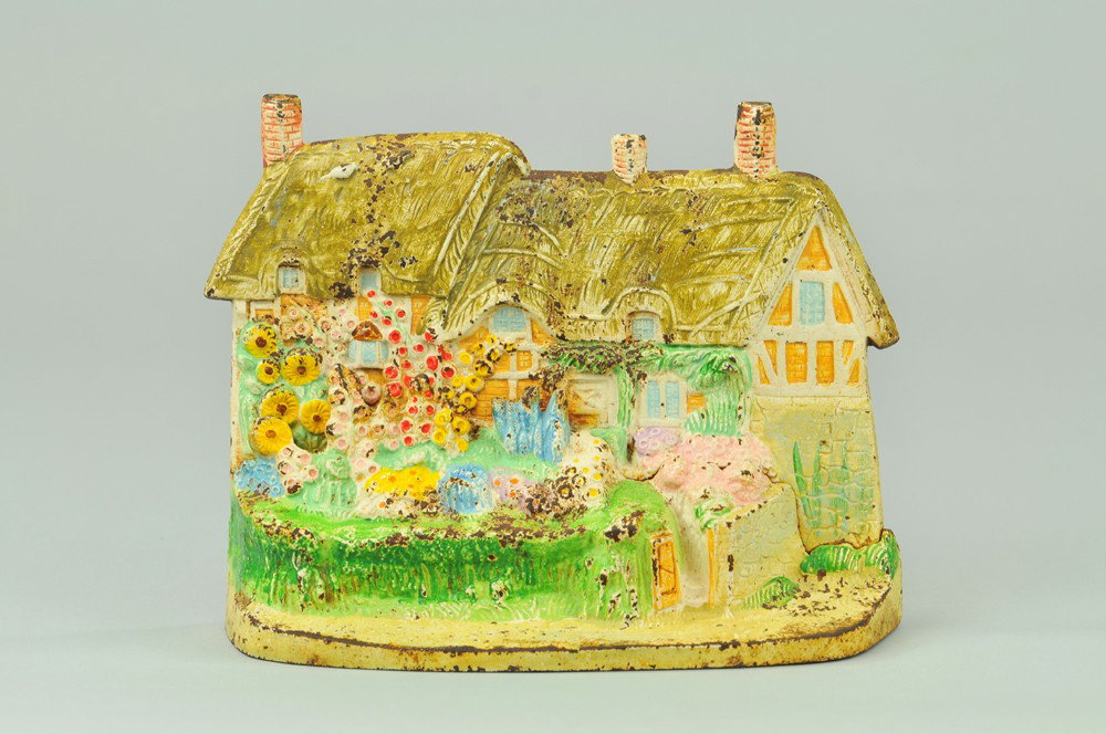ANN HATHAWAY COTTAGE DOORSTOP: Hubley, incredible two piece casting, intricate paint, depicted w/colorful display of garden arrangements. 6 1/2" x 8 3/8". (Exc. Cond.) 6 1/2" x 8 3/8".