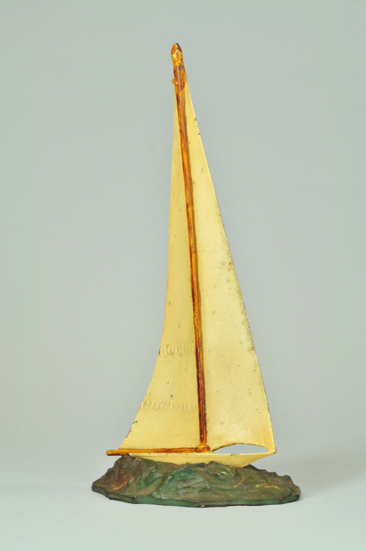 SAILBOAT DOORSTOP: Hubley, cast iron, rare two-piece casting, beautiful full figured casting of sailboat attached to cast ocean base. Wonderful size, very rare & unusual. 17" h. Base (Exc. Cond.); boat (Pristine Cond.) 