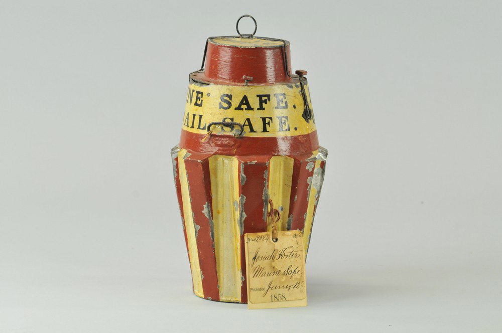 MARINE SAFE PATENT MODEL: Issued to Josiah Foster, 1858, tin can styled safe with screw down lid, able to float in water if needed, billed as Foster's Metallic Marine Safe, top lid reads, "Mail Bag". 11 1/4" h. Some paint loss