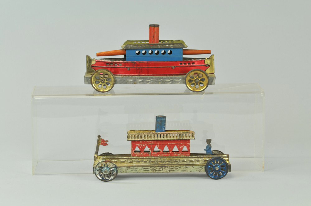 LOT OF TWO EARLY TIN SHIPS: Maker unknown, stamped tin, each has wheels and upper deck cabins, one with protruding guns. 10" -12" l. (Exc. Cond) 10" -12" l.