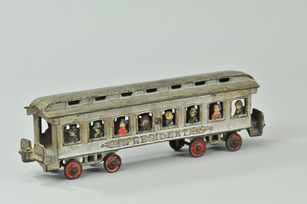 IVES PRESIDENT FLOOR TRAIN COACH: Scarce example, cast iron, painted in silver body, red trimmed figures at windows, very detailed molding to side lettering. 11" l. (VG Cond) 11" l.