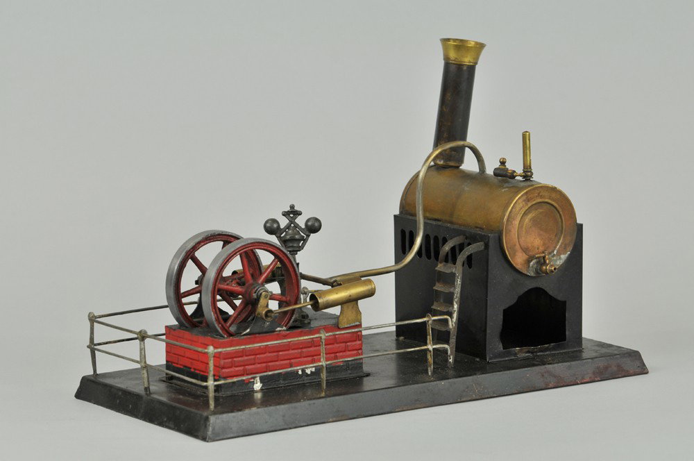 HORIZONTAL STEAM ENGINE: Twin oscillating cylinders and dual flywheels on raised brickwork base, steps lead to brass boiler, metal railed base. 13 1/2" l. Early resolder in places. 13 1/2" l.