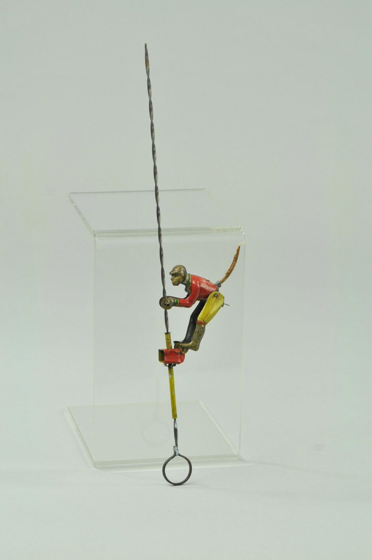 MONKEY ON SPIRAL PENNY TOY: Germany, lithographed tin penny toy features monkey climbing a spiral pole. 11" h. (Exc. Cond.) 11" h.